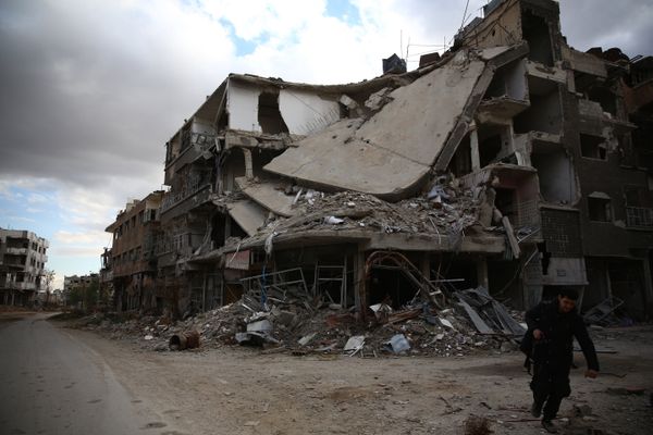 A photographer walks in the neighbourhood of Jobar, on the eastern outskirts of the capital Damascus, on January 23, 2016 - Sputnik International