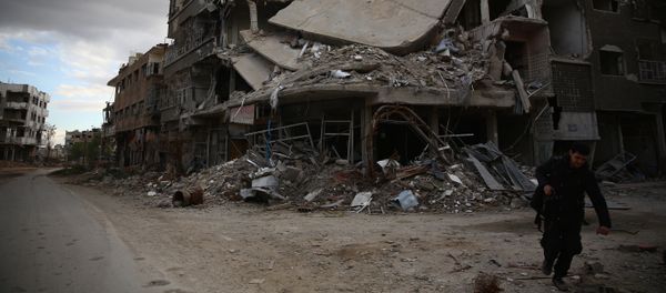 A photographer walks in the neighbourhood of Jobar, on the eastern outskirts of the capital Damascus, on January 23, 2016 - Sputnik International