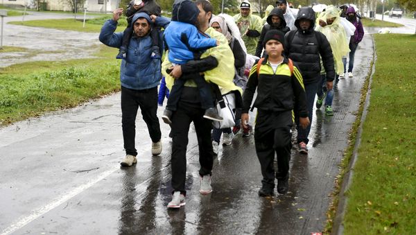 Refugees walk through the pouring rain from a public transport centre to the Lappia-building refugee reception centre in Tornio, northwestern Finland, on September 2015 Refugees walk through the pouring rain from a public transport centre to the Lappia-building refugee reception centre in Tornio, northwestern Finland, on September 2015 - Sputnik International