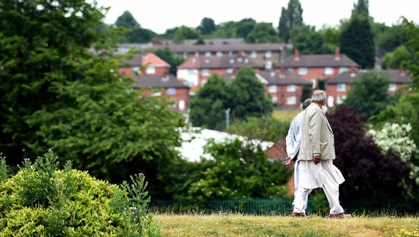 People walk in a park in Savile Town, Dewsbury People walk in a park in Savile Town, Dewsbury - Sputnik International