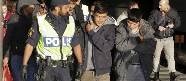 A group of migrants off an incoming train walk down a platform as they are accompanied by the police A group of migrants off an incoming train walk down a platform as they are accompanied by the police - Sputnik International