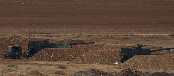 Men watch fighting across the border in Kobani from a hilltop on the outskirts of Suruc, Turkey, backdropped by Turkish army artillery positions near the Turkey-Syria border, Sunday, Oct. 26, 2014 Men watch fighting across the border in Kobani from a hilltop on the outskirts of Suruc, Turkey, backdropped by Turkish army artillery positions near the Turkey-Syria border, Sunday, Oct. 26, 2014 - Sputnik International