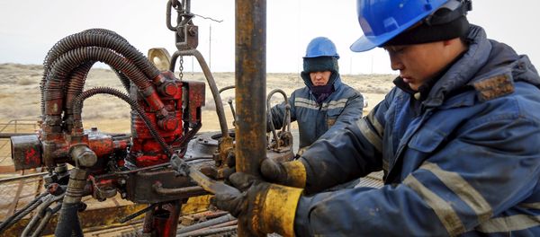 Workers carry out maintenance at an oil well on oil fields operated by a subsidiary of the KazMunayGas Exploration Production JSC in Kyzylorda region, southern Kazakhstan, January 21, 2016 - Sputnik International
