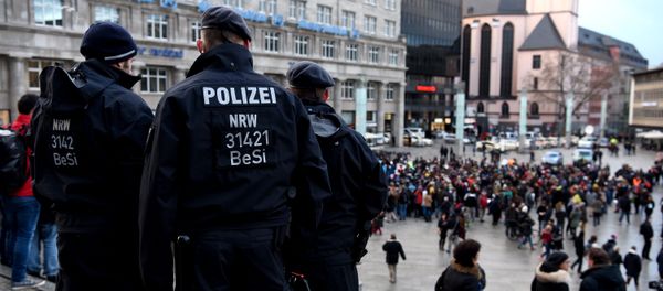 Policemen look on as refugees from Syria demonstrate against violence near the Cologne main train station in Cologne, western Germany on January 16, 2016 - Sputnik International