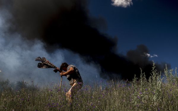 A local resident near a car that was hit during shelling of Lugansk - Krasnodon highway by Ukrainian armed forces. Photo by Valery Melnikov - Sputnik International