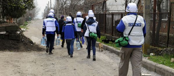 Monitors of the OSCE Special Monitoring Mission to Ukraine in Shirokine village, walk along a path on April 14, 2015 on the outskirts of the strategic port city of Mariupol Monitors of the OSCE Special Monitoring Mission to Ukraine in Shirokine village, walk along a path on April 14, 2015 on the outskirts of the strategic port city of Mariupol - Sputnik International