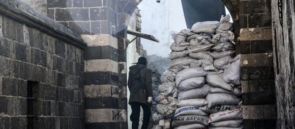 Kurdish fighter walks through barricads in the Sur district in Diyarbakir on December 11, 2015 - Sputnik International