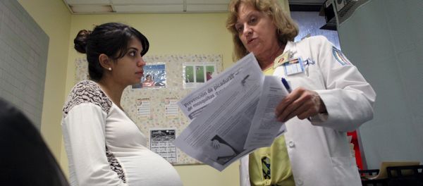 Nancy Trinidad, who is 32 weeks pregnant, listens to the explanation of a doctor about how to prevent Zika, Dengue and Chikungunya viruses at a public hospital in San Juan, Puerto Rico, February 3, 2016 - Sputnik International
