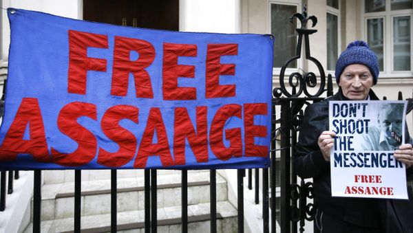 A demonstrator holds a banner outside the Ecuadorean Embassy in London, where Wikileaks founder Julian Assange is staying, Thursday, Feb. 4, 2016 - Sputnik International