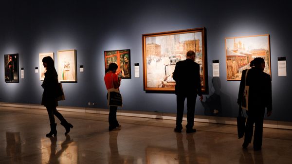 Visitors at the Palazzo delle Esposizioni in Rome attend an exhibition of paintings from the collection of the Institute for Russian Realist Art (IRRA), state-owned museums and private collections called 'Russia on the Road (1920-1990).' Center: The New Moscow by Yury Pimenov, courtesy of the State Tretyakov Gallery - Sputnik International