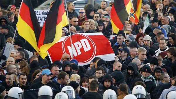 Supporters of anti-immigration right-wing movement PEGIDA (Patriotic Europeans Against the Islamisation of the West) hold up a banner with the logo of the far-right National Democratic Party (NPD) as they take part in in demonstration march, in reaction to mass assaults on women on New Year's Eve, in Cologne, Germany, January 9, 2016. Supporters of anti-immigration right-wing movement PEGIDA (Patriotic Europeans Against the Islamisation of the West) hold up a banner with the logo of the far-right National Democratic Party (NPD) as they take part in in demonstration march, in reaction to mass assaults on women on New Year's Eve, in Cologne, Germany, January 9, 2016. - Sputnik International