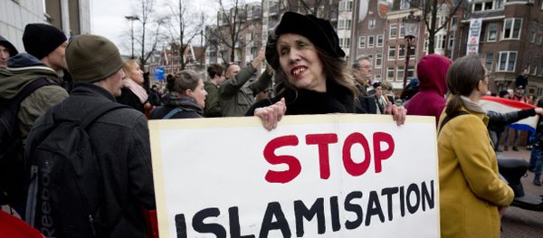 A woman holds a placard during a Pegida demonstration against immigration and islamization in Amsterdam, Netherlands - Sputnik International