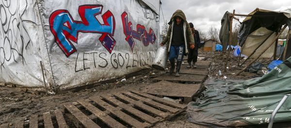 Migrants walk among tents in a muddy field at a camp of makeshift shelters for migrants and asylum-seekers from Iraq, Kurdistan, Iran and Syria, called the Grande Synthe jungle, near Calais, France Migrants walk among tents in a muddy field at a camp of makeshift shelters for migrants and asylum-seekers from Iraq, Kurdistan, Iran and Syria, called the Grande Synthe jungle, near Calais, France - Sputnik International