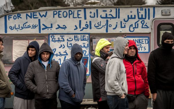 Refugees stand in the so-called Jungle migrant camp in Calais, northern France Refugees stand in the so-called Jungle migrant camp in Calais, northern France - Sputnik International