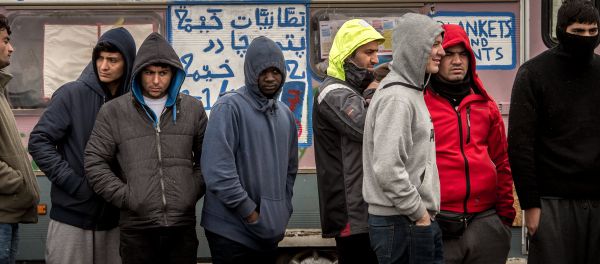 Refugees stand in the so-called Jungle migrant camp in Calais, northern France Refugees stand in the so-called Jungle migrant camp in Calais, northern France - Sputnik International