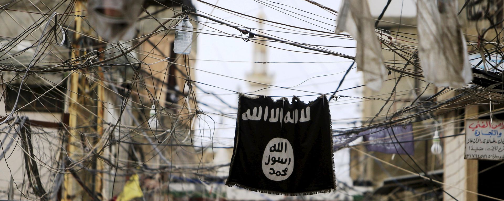 An Islamic State flag hangs amid electric wires over a street. An Islamic State flag hangs amid electric wires over a street. - Sputnik International, 1920, 06.09.2021