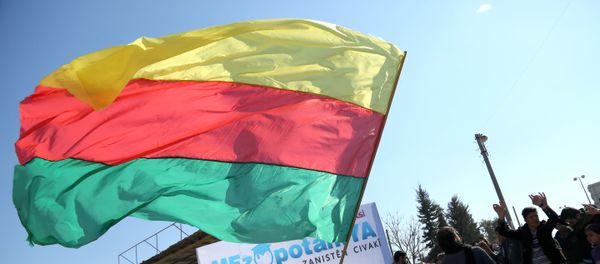 A Kurdish man waves a large flag of the Kurdish People's Protection Units (YPG) political wing, the Democratic Union Party (PYD), during a demonstration against the exclusion of Syrian-Kurds from the Geneva talks in the northeastern Syrian city of Qamishli on February 4, 2016 A Kurdish man waves a large flag of the Kurdish People's Protection Units (YPG) political wing, the Democratic Union Party (PYD), during a demonstration against the exclusion of Syrian-Kurds from the Geneva talks in the northeastern Syrian city of Qamishli on February 4, 2016 - Sputnik International