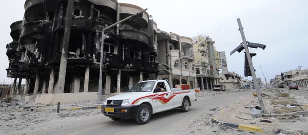 This file photo taken on October 24, 2011 shows Libyans driving through a destroyed neighbourhood in Sirte This file photo taken on October 24, 2011 shows Libyans driving through a destroyed neighbourhood in Sirte - Sputnik International