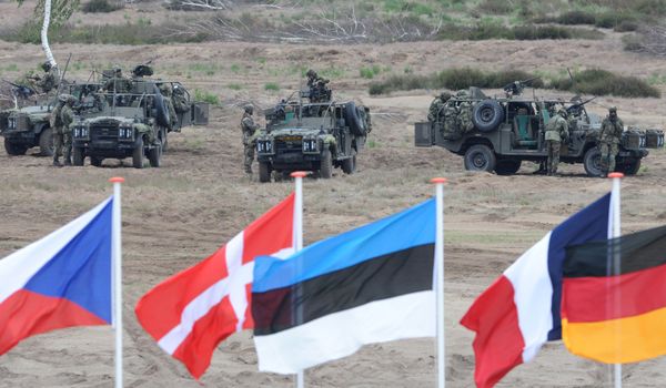In this June 18, 2015,file photo flags wave in front of soldiers who take positions with their army vehicles during the NATO Noble Jump exercise on a training range near Swietoszow Zagan, Poland - Sputnik International