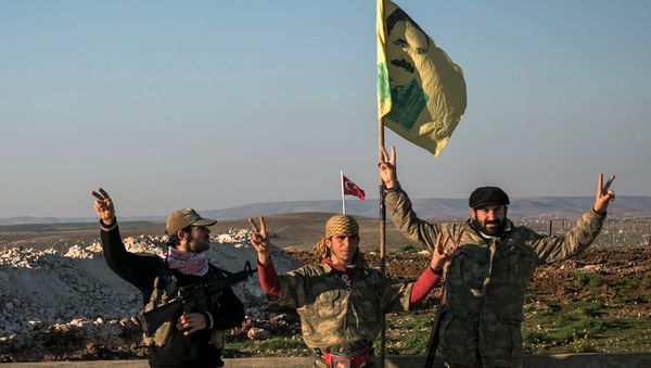 FILE - In this Sunday, Feb. 22, 2015, file photo, Syrian Kurdish militia members of YPG make a V-sign next to poster of Abdullah Ocalan, jailed Kurdish rebel leader, and a Turkish army tank in the background in Esme village in Aleppo province, Syria FILE - In this Sunday, Feb. 22, 2015, file photo, Syrian Kurdish militia members of YPG make a V-sign next to poster of Abdullah Ocalan, jailed Kurdish rebel leader, and a Turkish army tank in the background in Esme village in Aleppo province, Syria - Sputnik International