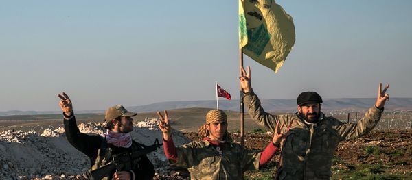 FILE - In this Sunday, Feb. 22, 2015, file photo, Syrian Kurdish militia members of YPG make a V-sign next to poster of Abdullah Ocalan, jailed Kurdish rebel leader, and a Turkish army tank in the background in Esme village in Aleppo province, Syria - Sputnik International