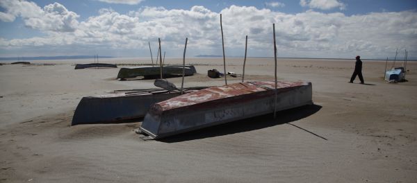 In this Jan. 12, 2016 photo, a fisherman walks along the abandoned boats in the dried up Lake Poopo, on the outskirts of Untavi, Bolivia In this Jan. 12, 2016 photo, a fisherman walks along the abandoned boats in the dried up Lake Poopo, on the outskirts of Untavi, Bolivia - Sputnik International
