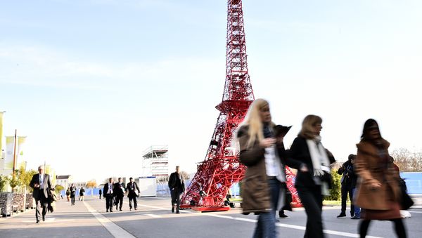 People pass by a miniature Eiffel Tower displayed at the COP21, the United Nations conference on climate at Le Bourget, on the outskirts of Paris on December 3, 2015. - Sputnik International