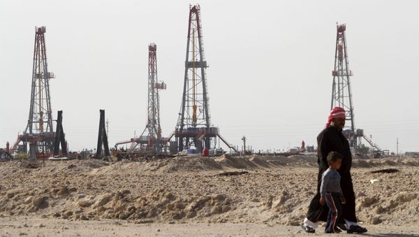 Iraqi people walk past the Rumaila oilfield in Basra, Iraq, January 26, 2016 - Sputnik International