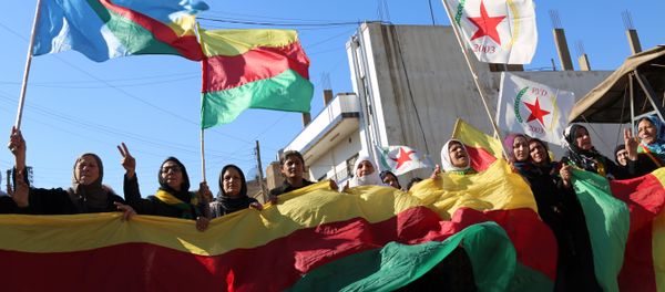 Kurdish women hold flags of the Kurdish People's Protection Units (YPG) political wing, the Democratic Union Party (PYD), and banners during a demonstration against the exclusion of Syrian-Kurds from the Geneva talks in the northeastern Syrian city of Qamishli on February 4, 2016 - Sputnik International