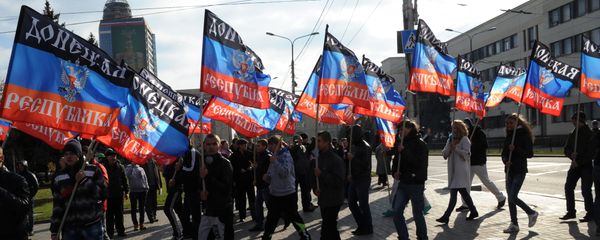 People carry flags of the self-proclaimed Donetsk People's Republic (DPR) during a ceremony for the presentation of the DPR flag at the Lenin square of Donetsk, on October 19, 2014 - Sputnik International