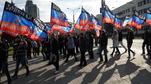People carry flags of the self-proclaimed Donetsk People's Republic (DPR) during a ceremony for the presentation of the DPR flag at the Lenin square of Donetsk, on October 19, 2014 - Sputnik International
