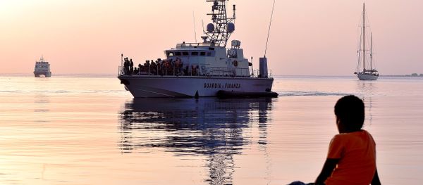 A migrant boy watches an Italian Frontex vessel loaded by intercepted migrants arriving to the port of Kos on August 16, 2015, on the island of Kos. - Sputnik International