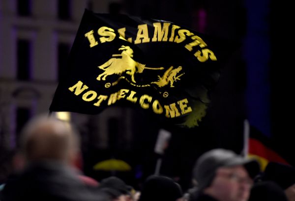 A flag reading Islamists not welcome flies among protestors from the PEGIDA movement (Patriotic Europeans Against the Islamisation of the Occident) attend a rally in Leipzig on January 11, 2016 - Sputnik International