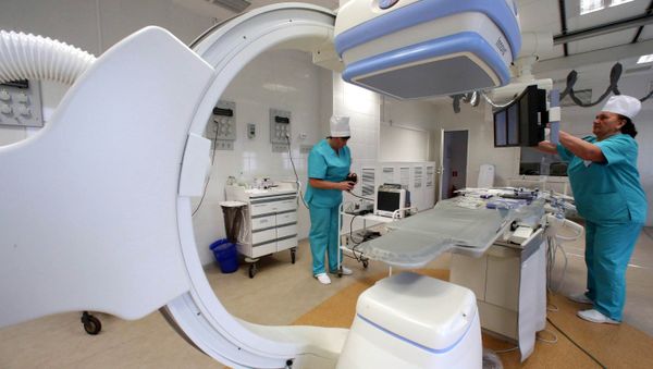 A surgical nurse at the X-ray surgery department of the Baltic Fleet's hospital, adjusting the settings of an angiography machine, before using it during a surgery - Sputnik International