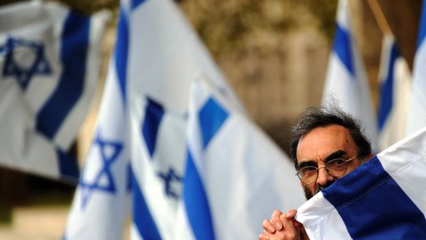 A man holds an Israeli fag during a counter demonstration against a nearby protest opposite Downing Street in central London, on October 6, 2011. - Sputnik International