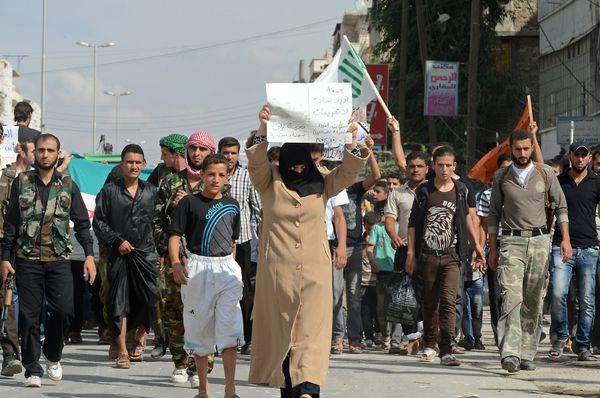 A Syrian woman holds a sign calling for the arming of rebels as civilians and Free Syrian Army members march during a protest against the Syrian government in the northern city of Aleppo on October 5, 2012 - Sputnik International