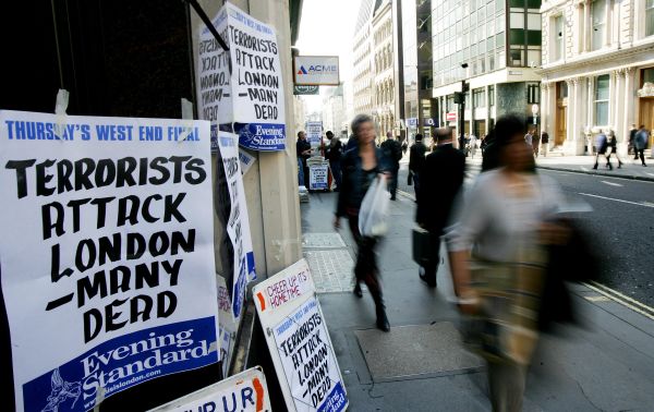 Pedestrians walk past a newspaper stand announcing the terrorist attacks after subway and bus lines were closed in London 07 July 2005. - Sputnik International