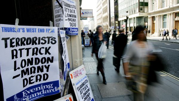 Pedestrians walk past a newspaper stand announcing the terrorist attacks after subway and bus lines were closed in London 07 July 2005. Pedestrians walk past a newspaper stand announcing the terrorist attacks after subway and bus lines were closed in London 07 July 2005. - Sputnik International
