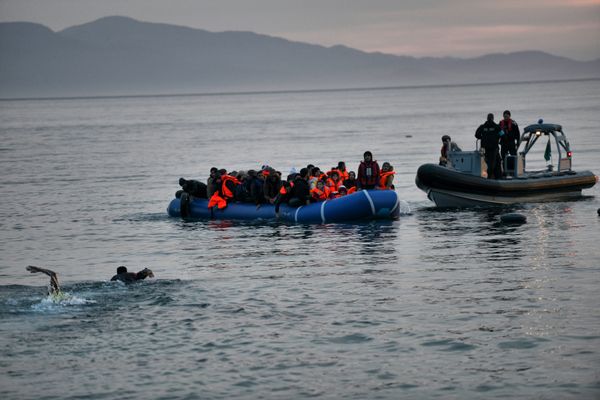 Refugees and migrants massed onto an inflatable boat reach Mytilene, northern island of Lesbos, after crossing the Aegean sea from Turkey on February 17, 2016 - Sputnik International