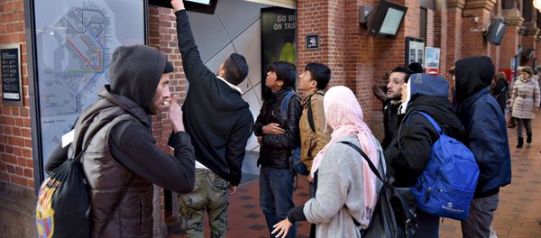 A group of migrants check a departure board at Copenhagen Central Station, Denmark - Sputnik International