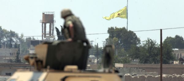 In this photo taken from the Turkish side of the border between Turkey and Syria, in Akcakale, southeastern Turkey, a Turkish soldier on an armoured personnel carrier watches as in the background a flag of the Kurdish People's Protection Units, or YPG, is raised over the city of Tal Abyad, Syria, Tuesday, June 16, 2015 In this photo taken from the Turkish side of the border between Turkey and Syria, in Akcakale, southeastern Turkey, a Turkish soldier on an armoured personnel carrier watches as in the background a flag of the Kurdish People's Protection Units, or YPG, is raised over the city of Tal Abyad, Syria, Tuesday, June 16, 2015 - Sputnik International