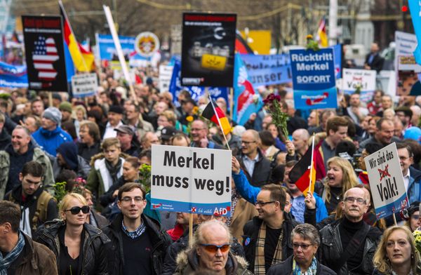 A supporter of the right-wing populist Alternative for Germany (AfD) party displays a placard showing crossed out Niqabs during a demonstration against the German government's asylum policy organized by the AfD party on November in Berlin on November 7, 2015. - Sputnik International