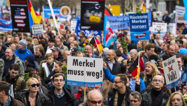 A supporter of the right-wing populist Alternative for Germany (AfD) party displays a placard showing crossed out Niqabs during a demonstration against the German government's asylum policy organized by the AfD party on November in Berlin on November 7, 2015. A supporter of the right-wing populist Alternative for Germany (AfD) party displays a placard showing crossed out Niqabs during a demonstration against the German government's asylum policy organized by the AfD party on November in Berlin on November 7, 2015. - Sputnik International