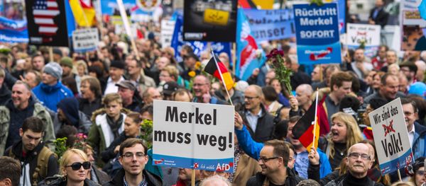 A supporter of the right-wing populist Alternative for Germany (AfD) party displays a placard showing crossed out Niqabs during a demonstration against the German government's asylum policy organized by the AfD party on November in Berlin on November 7, 2015. A supporter of the right-wing populist Alternative for Germany (AfD) party displays a placard showing crossed out Niqabs during a demonstration against the German government's asylum policy organized by the AfD party on November in Berlin on November 7, 2015. - Sputnik International