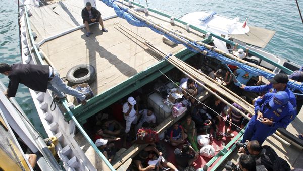 In this May 12, 2013 file photo, Iranian asylum seekers who were caught in Indonesian waters while sailing to Australia, sit on a boat, at Benoa port in Bali, Indonesia In this May 12, 2013 file photo, Iranian asylum seekers who were caught in Indonesian waters while sailing to Australia, sit on a boat, at Benoa port in Bali, Indonesia - Sputnik International