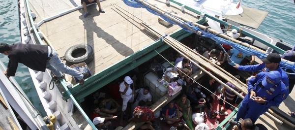 In this May 12, 2013 file photo, Iranian asylum seekers who were caught in Indonesian waters while sailing to Australia, sit on a boat, at Benoa port in Bali, Indonesia In this May 12, 2013 file photo, Iranian asylum seekers who were caught in Indonesian waters while sailing to Australia, sit on a boat, at Benoa port in Bali, Indonesia - Sputnik International