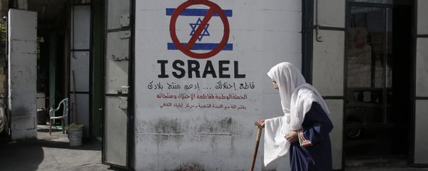 A Palestinian woman walks past a mural calling people to boycott Israeli goods in the al-Azzeh refugee camp near the West Bank city of Bethlehem on September 17, 2014 - Sputnik International