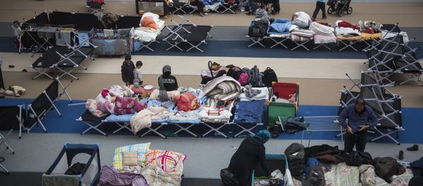 Immigrants rest on camp beds installed at the Horst Korber sports hall at the Berlin Olympic stadium complex Olympiapark on October 23, 2015 Immigrants rest on camp beds installed at the Horst Korber sports hall at the Berlin Olympic stadium complex Olympiapark on October 23, 2015 - Sputnik International