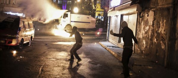 Protesters run after they threw a petrol bomb against a Turkish police water cannon during clashes in Istanbul, Sunday, Feb. 14, 2016, between police forces and people protesting against security operations against Kurdish rebels in southeastern Turkey Protesters run after they threw a petrol bomb against a Turkish police water cannon during clashes in Istanbul, Sunday, Feb. 14, 2016, between police forces and people protesting against security operations against Kurdish rebels in southeastern Turkey - Sputnik International