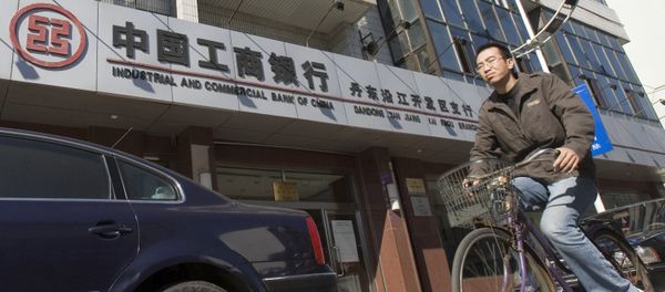 A man rides past a branch of the Industrial and Commercial Bank of China in the border city of Dandong in northeast China - Sputnik International